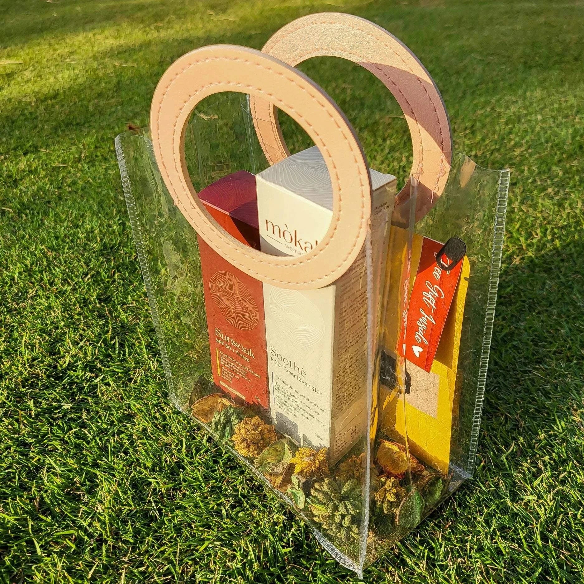 Mòkah Pollution Protect Duo in a stylish clear bag on grass, featuring skin barrier protection products for hydration and sun defense.